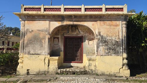 Free Traditional Indian building facade with intricate arch and aged texture. Stock Photo