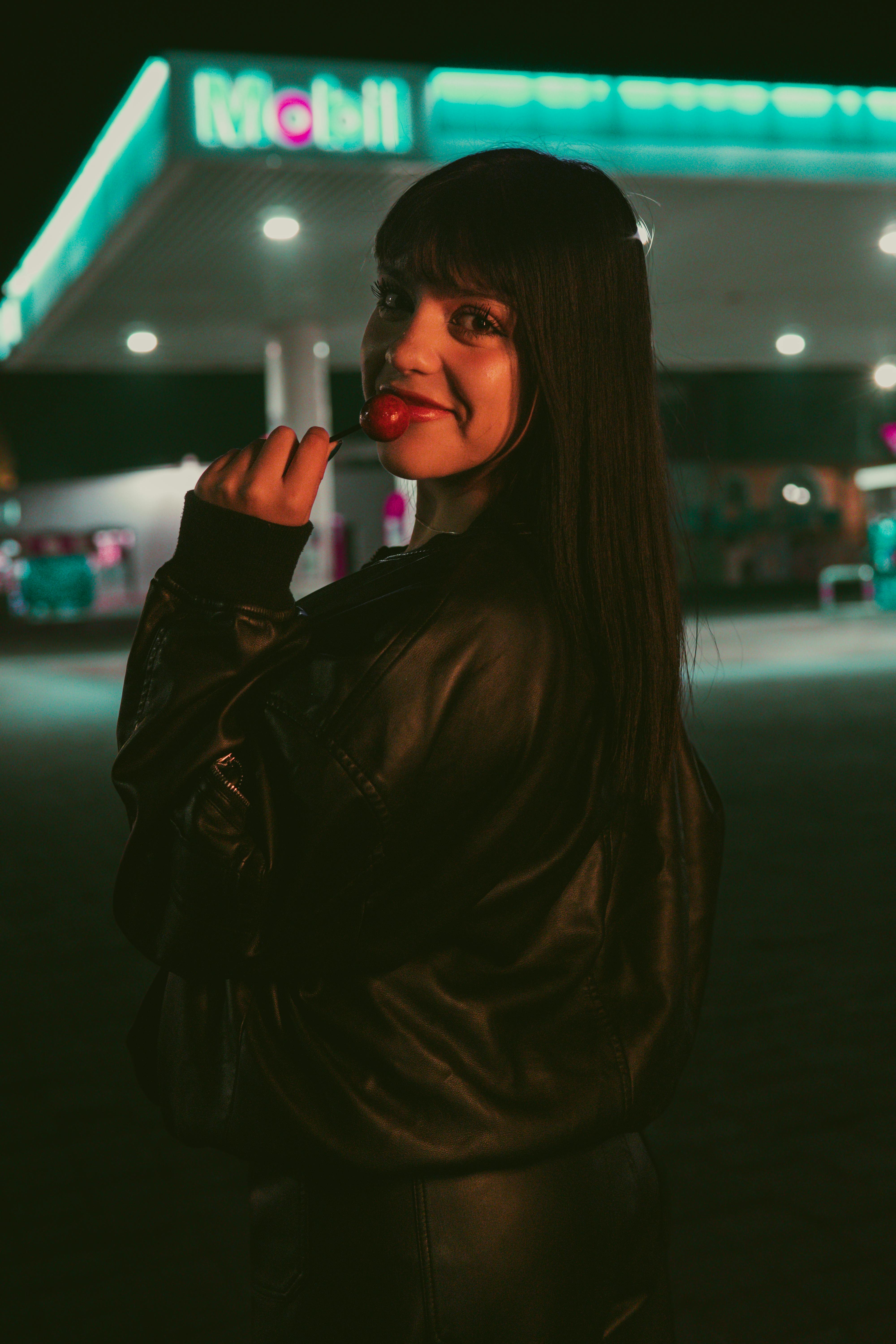 Δωρεάν Πορτρέτο μιας γυναίκας σε βενζινάδικο στην Τσολούλα τη νύχτα, που αποπνέει μια δροσερή και μελαγχολική ατμόσφαιρα. Φωτογραφία από στοκ φωτογραφιών