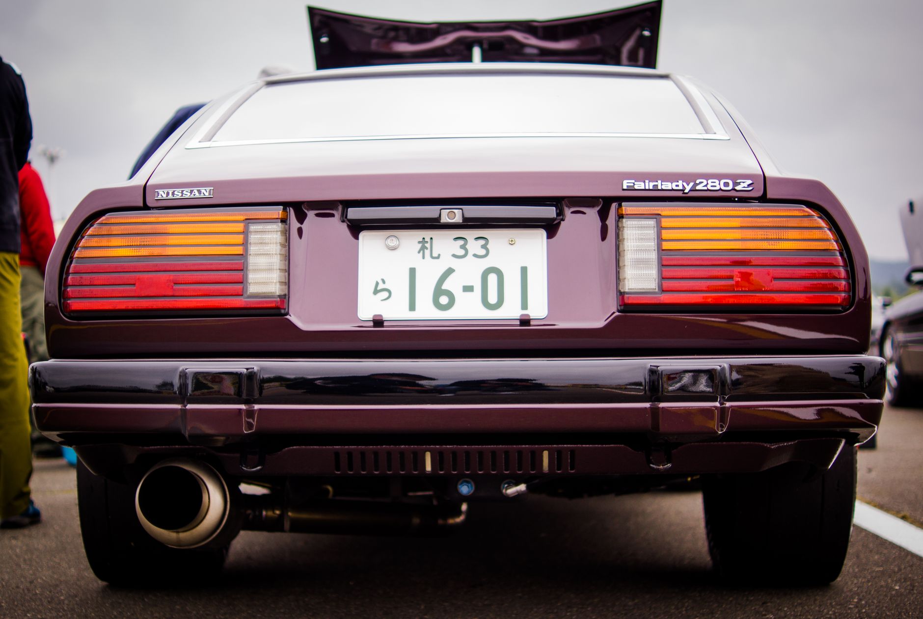 Close-up rear view of a classic Nissan Fairlady 280Z with vivid license plate details.