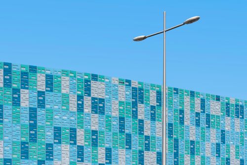 Free A vibrant modern building facade with a street lamp against a blue sky. Stock Photo