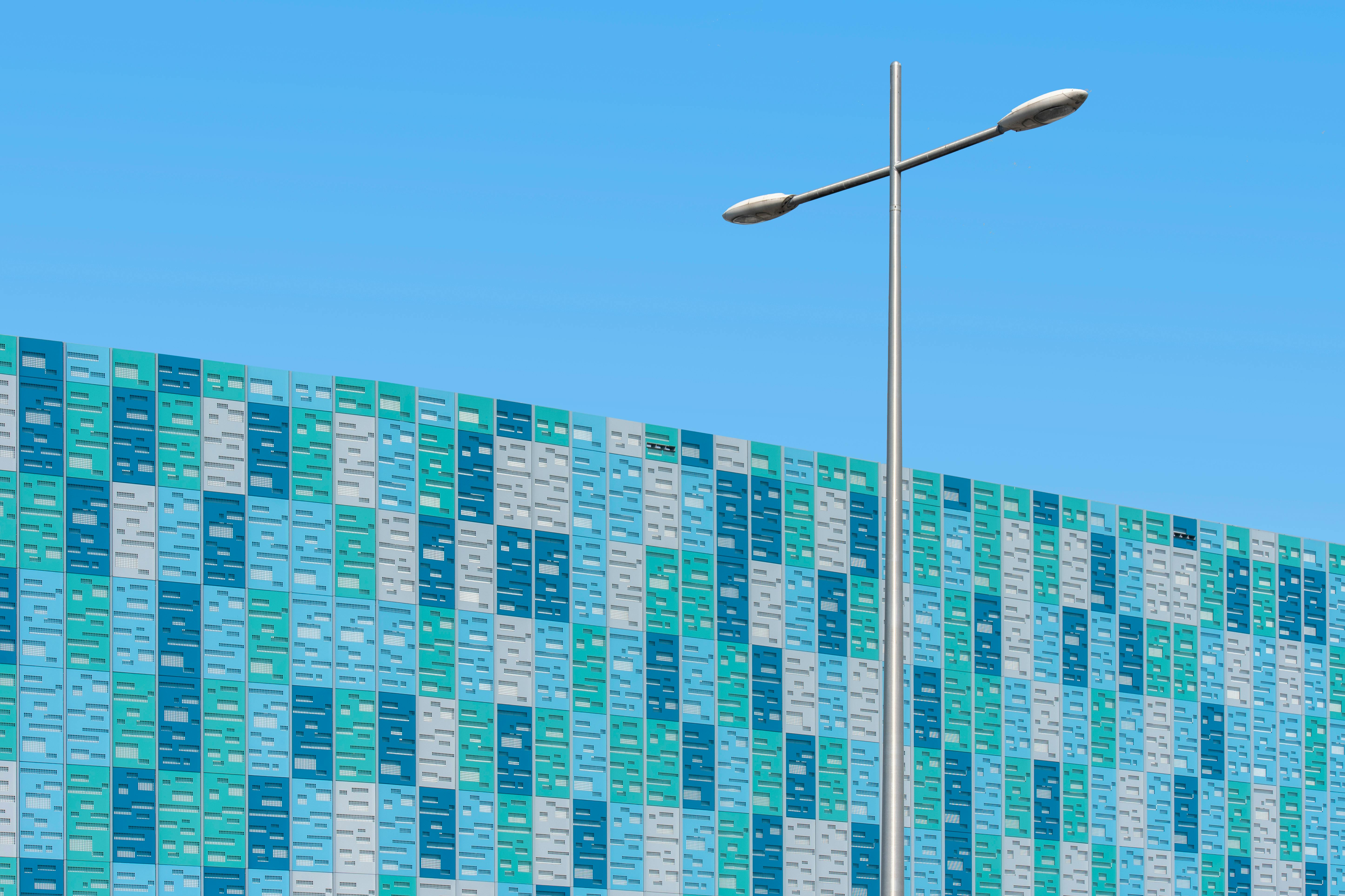 gratis Een levendige, moderne gebouwgevel met een straatlantaarn tegen een blauwe lucht. Stockfoto