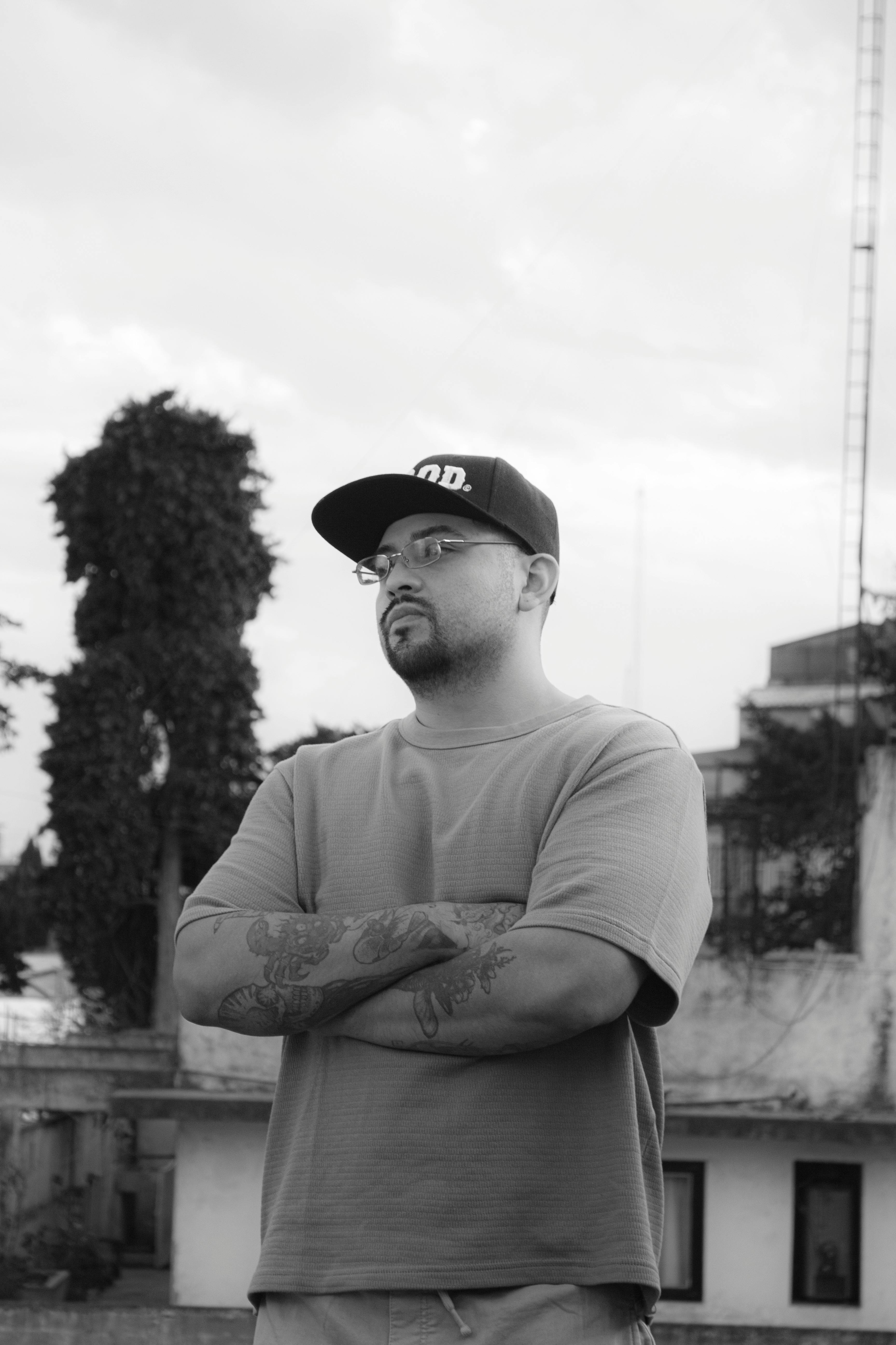 ฟรี ภาพถ่ายขาวดำของชายหนุ่มที่มีรอยสักยืนอยู่กลางแจ้งด้วยท่าทีสงบในประเทศเม็กซิโก คลังภาพถ่าย