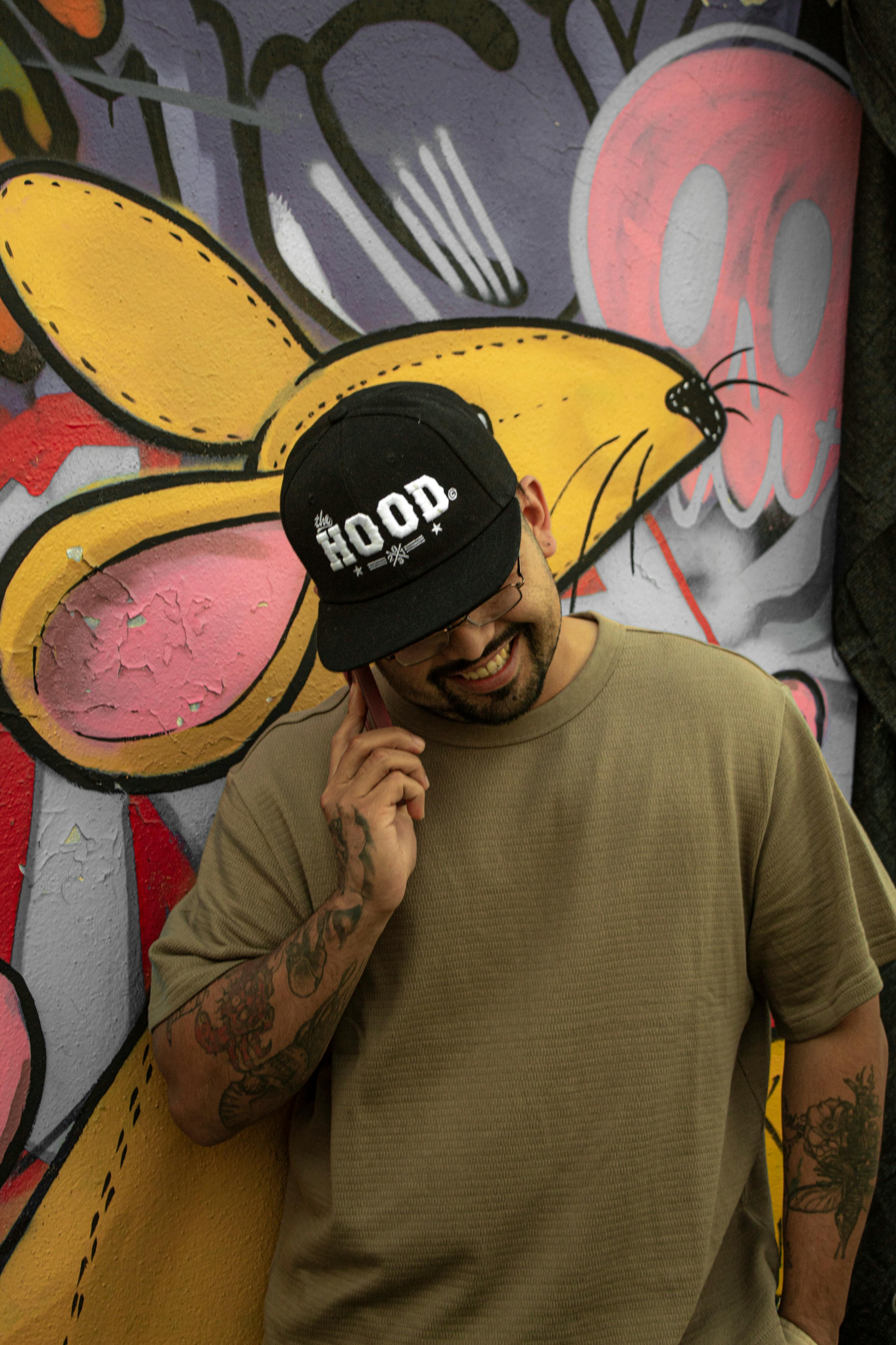 Δωρεάν Άνδρας που χαμογελά με πολύχρωμα γκράφιτι τέχνης του δρόμου στο σοκάκι της Πόλης του Μεξικού. Φωτογραφία από στοκ φωτογραφιών