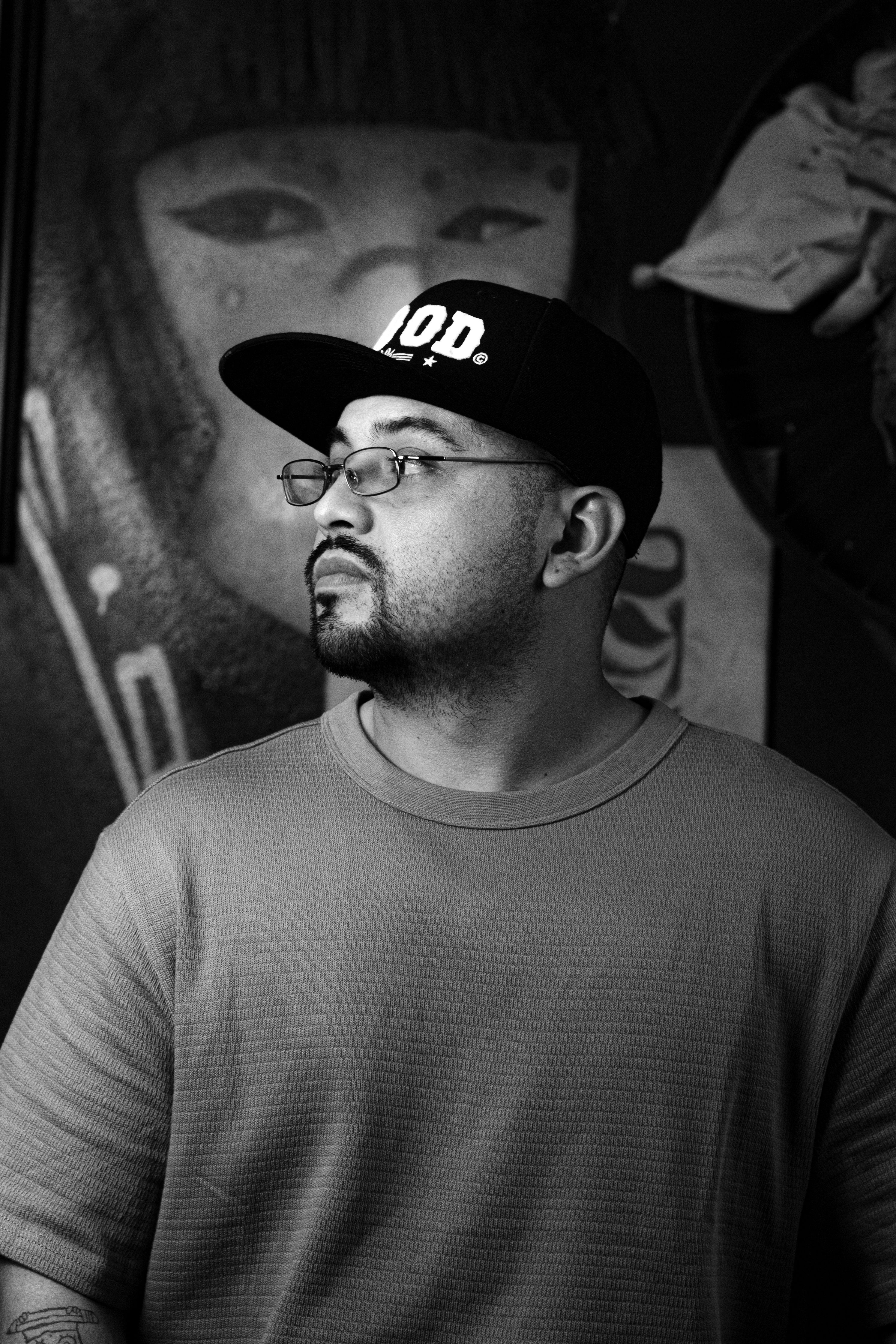 Artistic black and white portrait of a man against a graffiti background, Mexico.