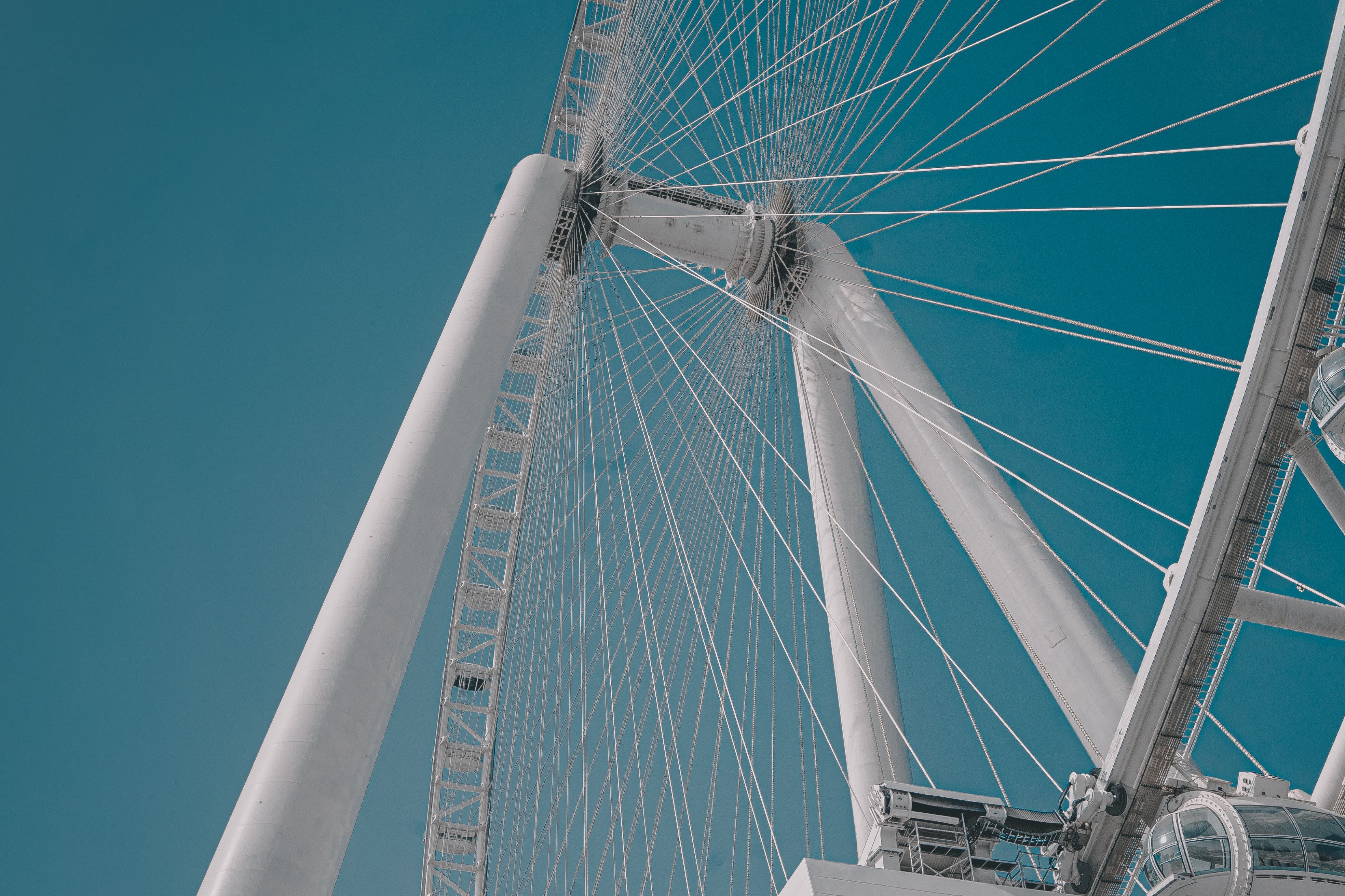 A dramatic upward angle of the Ain Dubai Ferris Wheel against a clear sky.