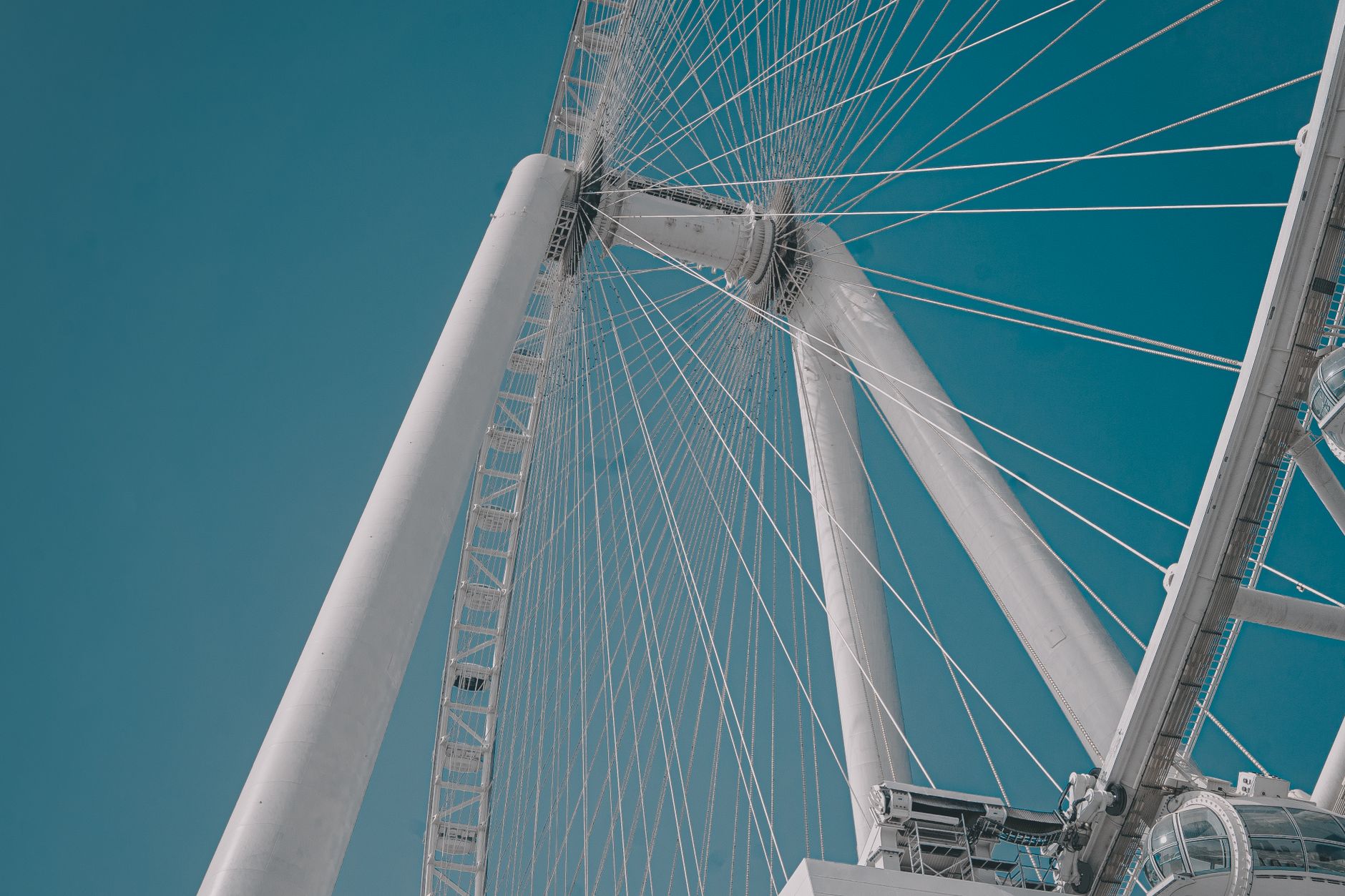 A dramatic upward angle of the Ain Dubai Ferris Wheel against a clear sky.