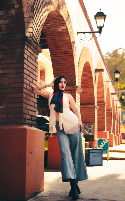 Free Stylish woman posing by urban arches in casual attire, capturing modern fashion. Stock Photo