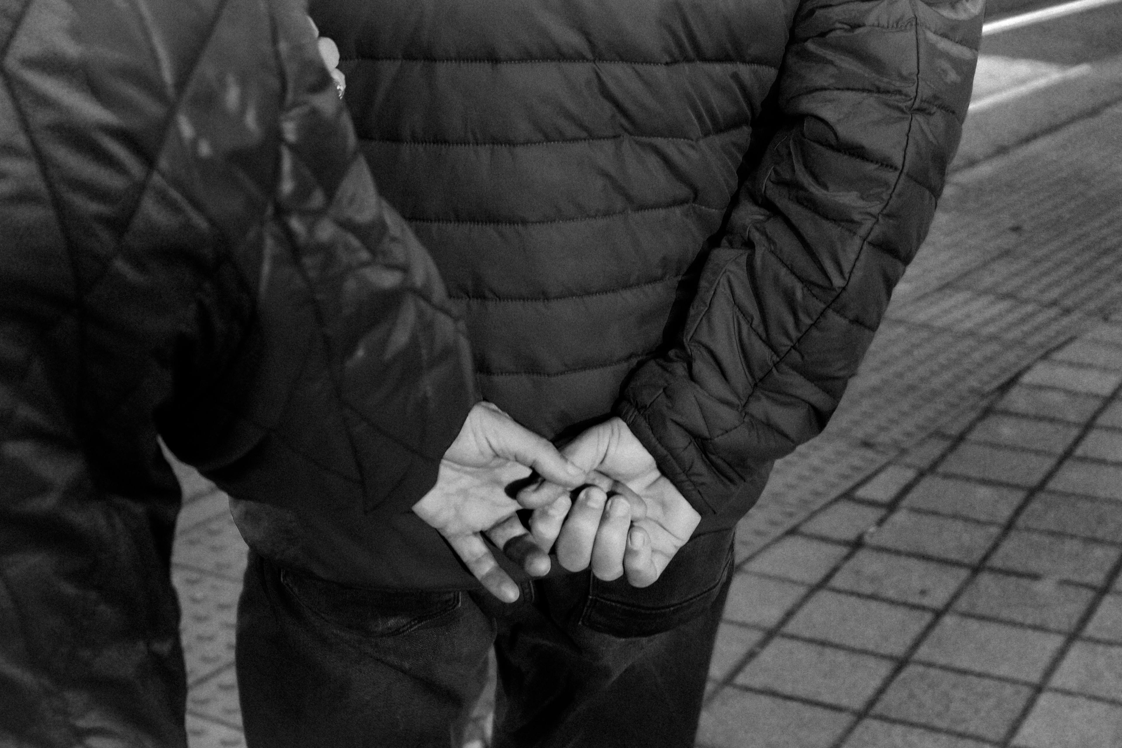 Bezpłatne Zbliżenie na ręce w kieszeniach, ukazujące swobodną modę uliczną w monochromatycznej tonacji. Zdjęcie z galerii