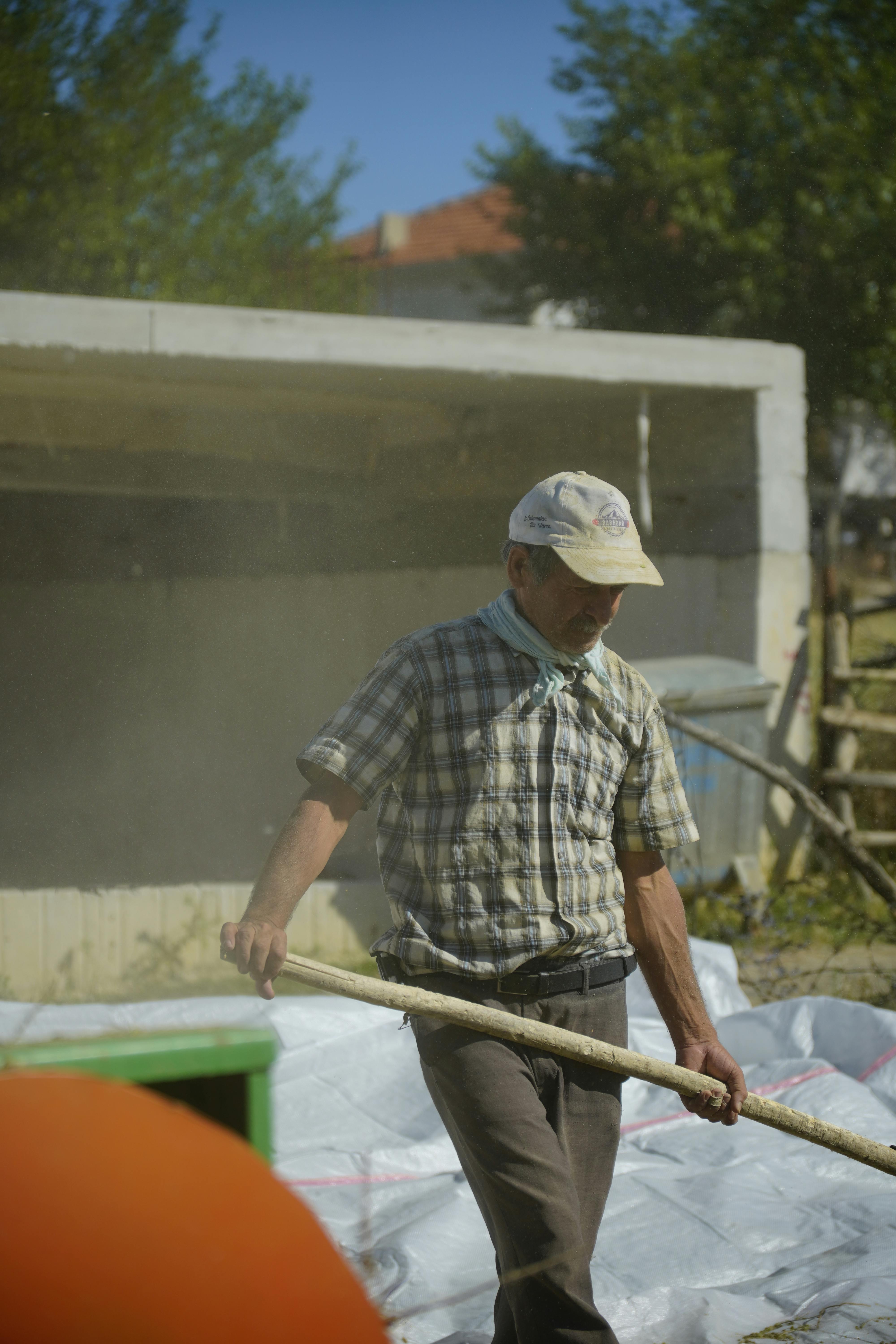 bezplatná Oddaný farmář v Turecku se během slunečného letního dne věnuje práci venku a ukazuje tak venkovský život. Základová fotografie