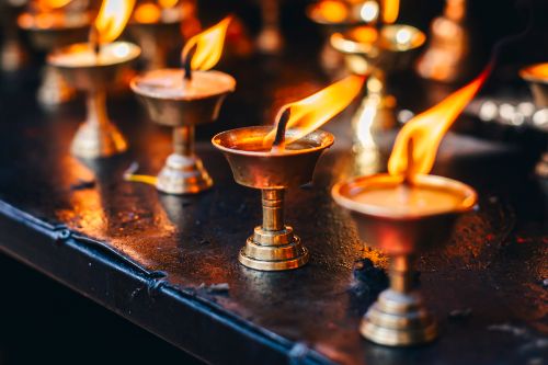 Free Beautiful close-up of traditional brass oil lamps with glowing flames, creating a warm and spiritual atmosphere. Stock Photo