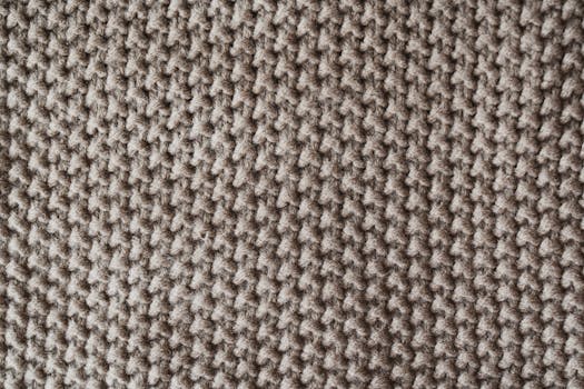 Detailed close-up of a textured knitted wool fabric, ideal for textile and pattern designs.