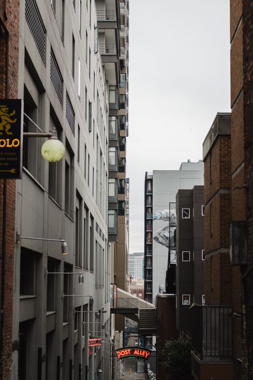 Free A narrow view of Seattle's Post Alley with urban architecture and overcast sky. Stock Photo