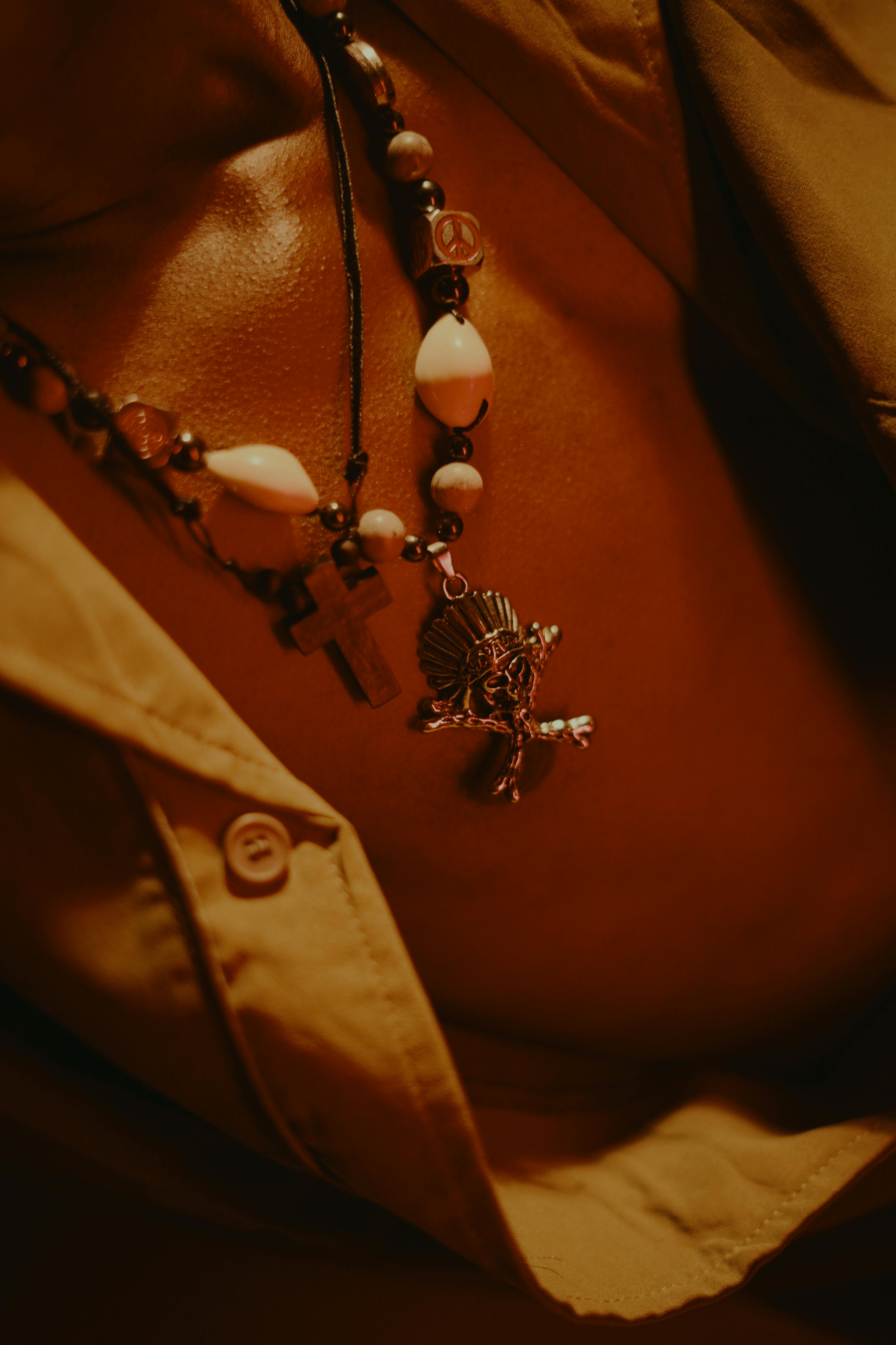 Free Pendant necklace on chest showing tribal design beads and warm lighting. Stock Photo