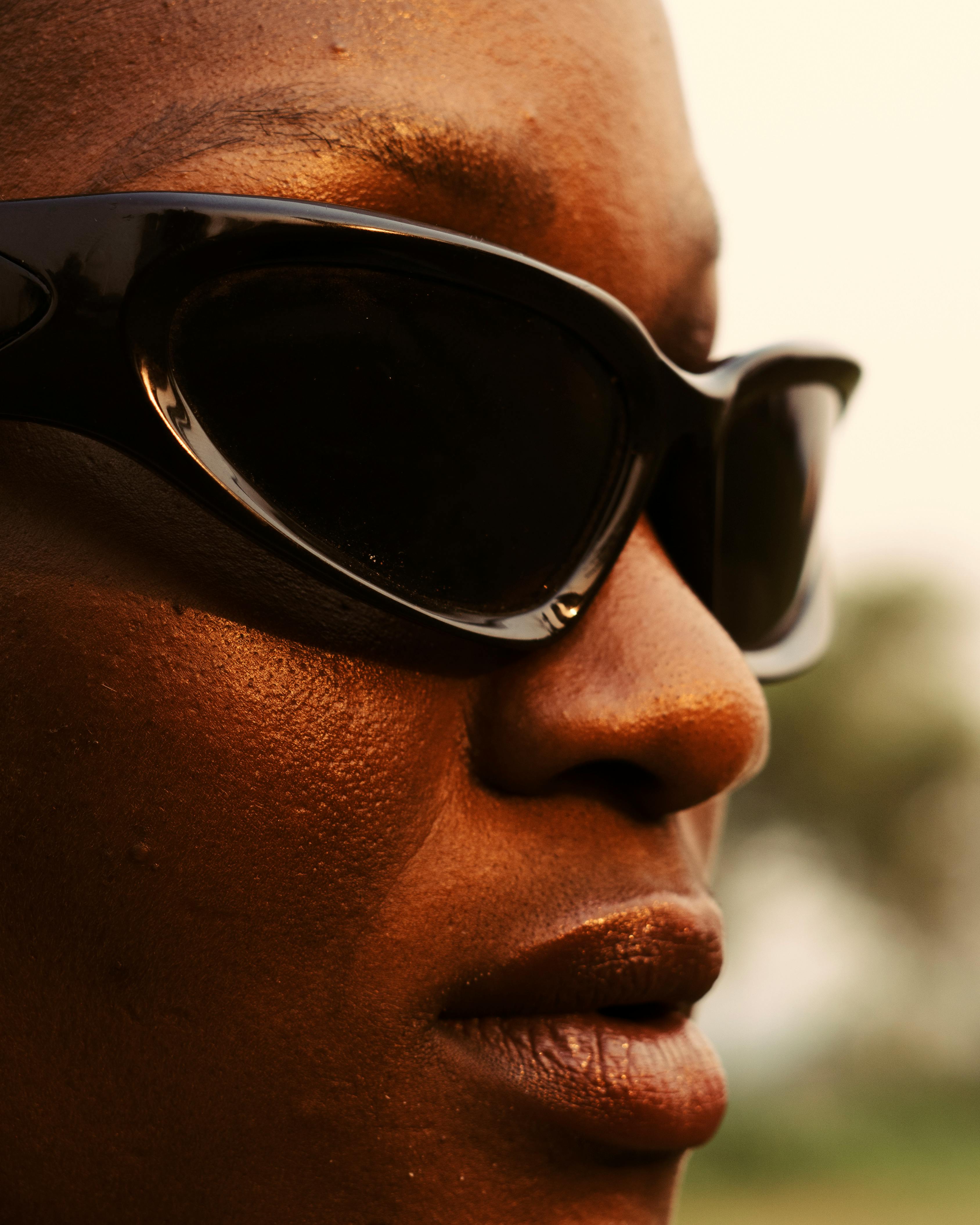 Miễn phí Cận cảnh một phụ nữ da đen đeo kính râm hiện đại ngoài trời, thể hiện phong cách thời trang và sự tự tin. Ảnh lưu trữ