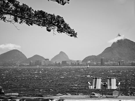 Monochrome photo of Rio's famous mountains and waterfront with lounging chairs.