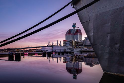 Free Stunning twilight view of Gothenburg harbor with boat and Läppstiftet reflecting in calm waters. Stock Photo