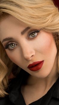 Close-up portrait of a woman with stylish makeup and blonde hair, showcasing elegance and beauty.
