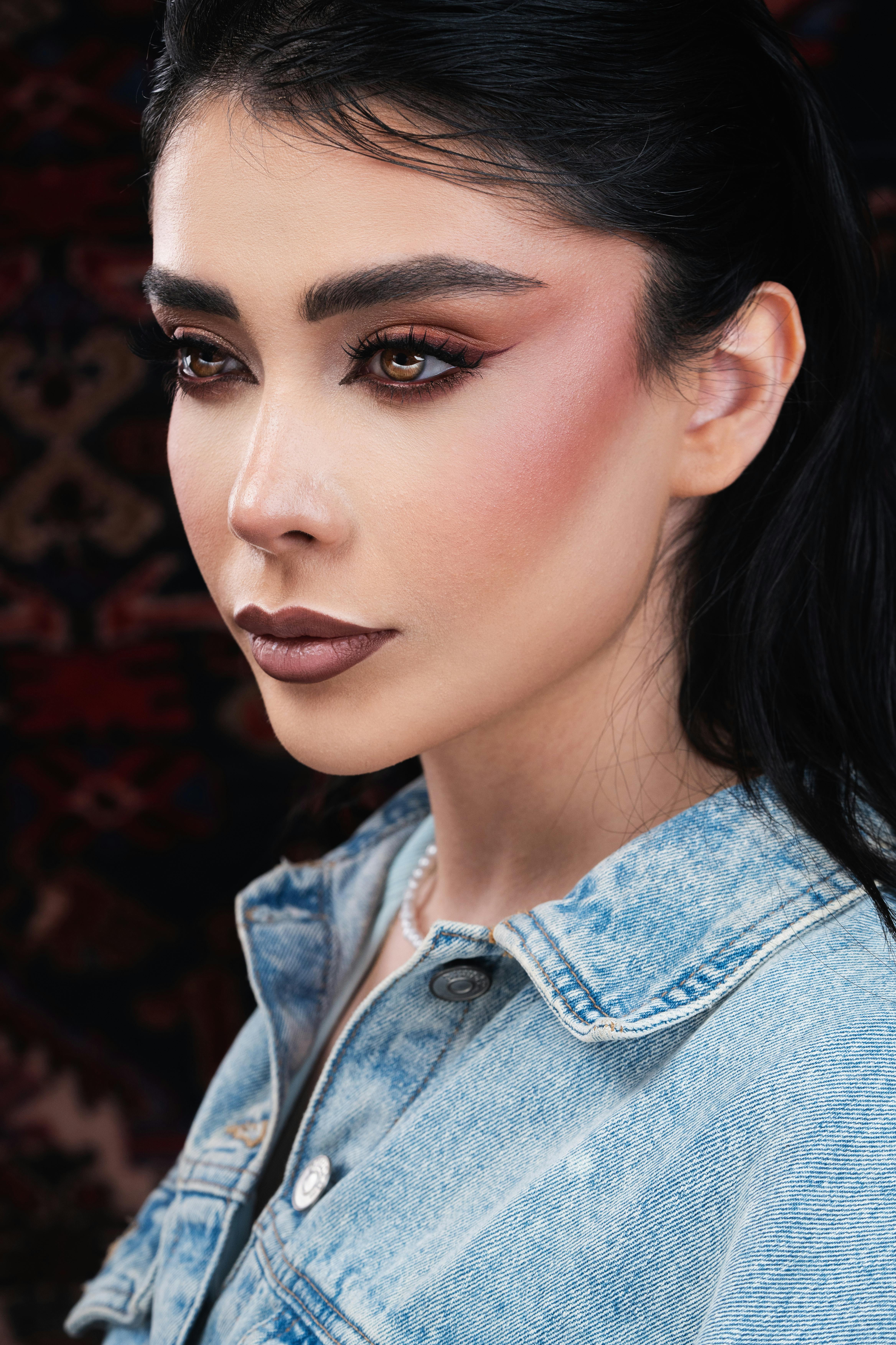 Gratis Splendido ritratto di una donna con un trucco audace che indossa una giacca di jeans, a dimostrazione dell'eleganza. Foto a disposizione