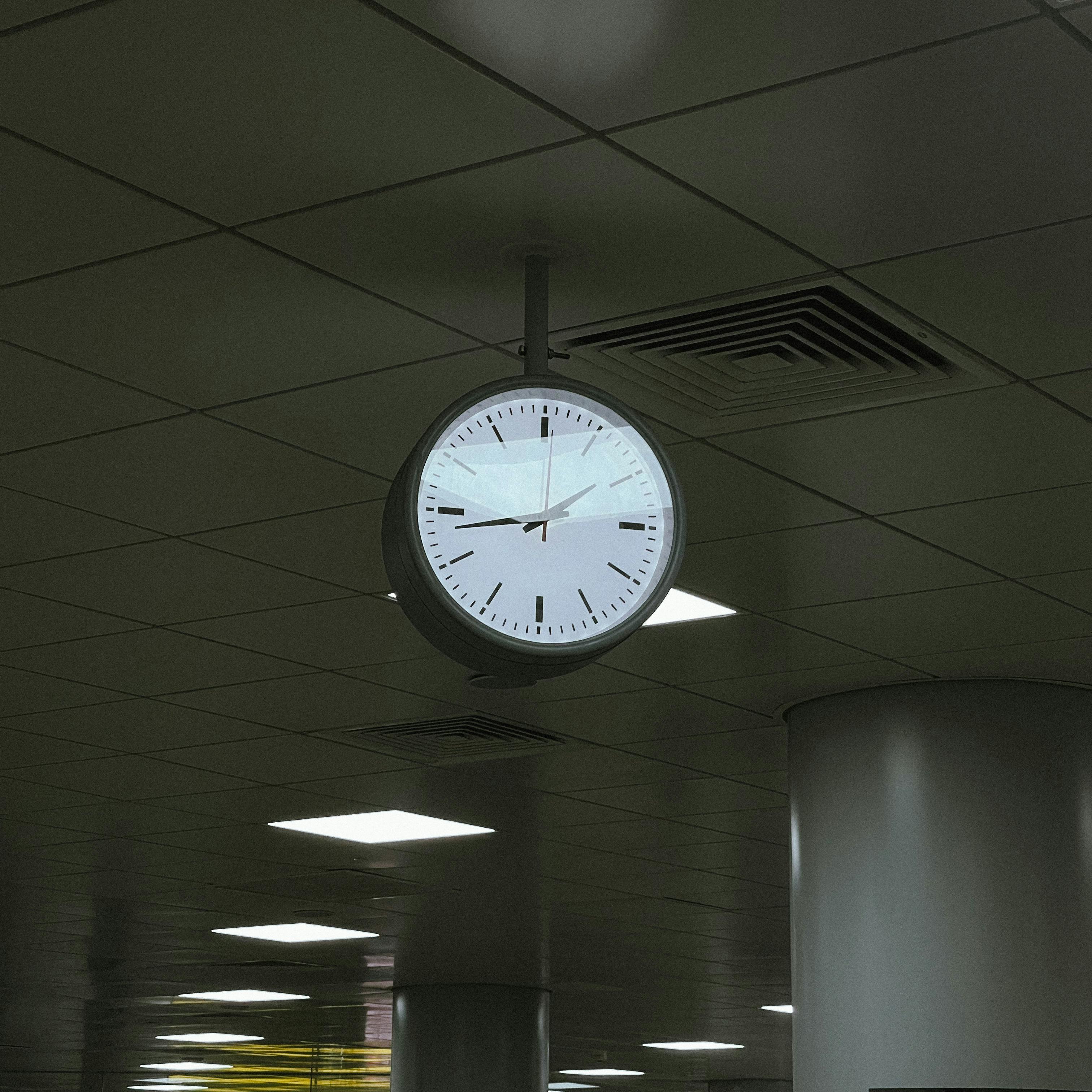 Gratis Un orologio montato a soffitto in un moderno ambiente interno con illuminazione fluorescente. Foto a disposizione