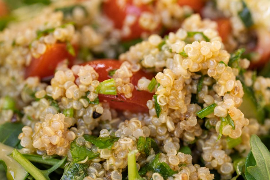Close-up of cooked quinoa with fresh herbs and vegetables mixed throughout
