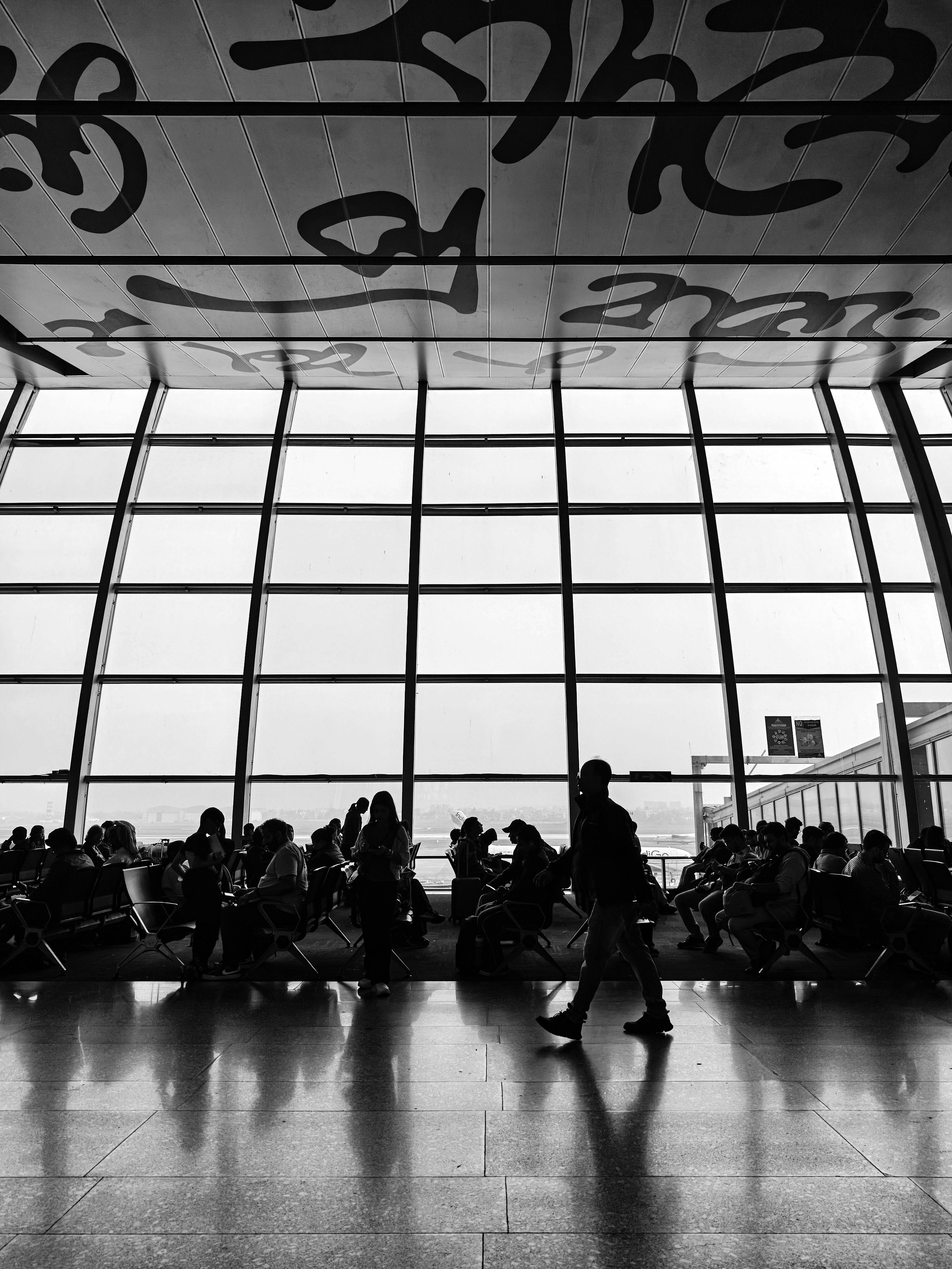 grátis Silhueta de viajantes dentro de um terminal de aeroporto com arquitetura moderna. Foto profissional