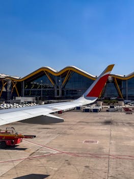 View from airplane window of airport terminal with unique architecture in Spain.
