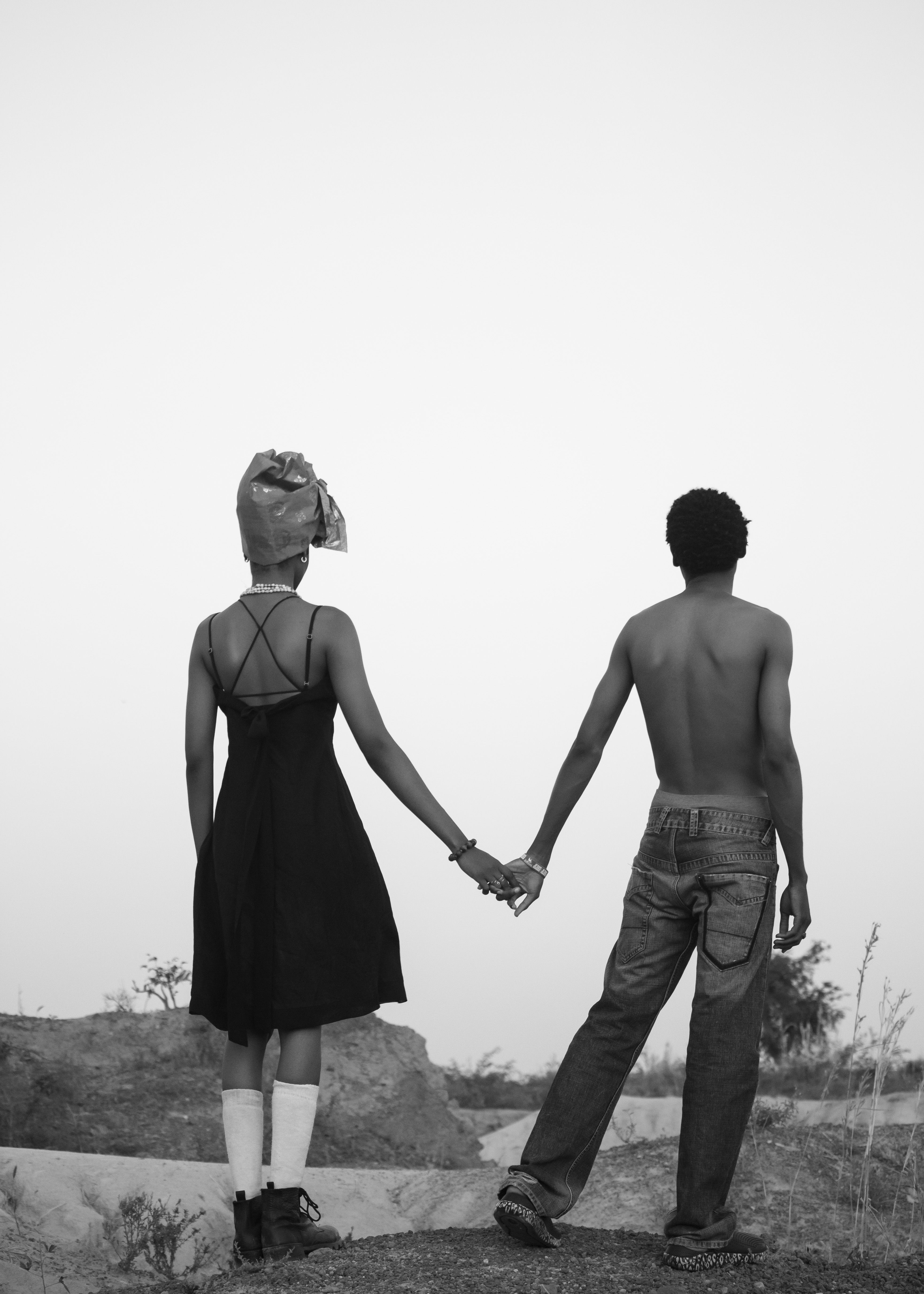 Back view of couple holding hands outdoors · Free Stock Photo