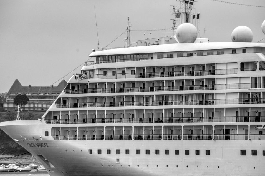 Luxury cruise ship docked in harbor with blue sky