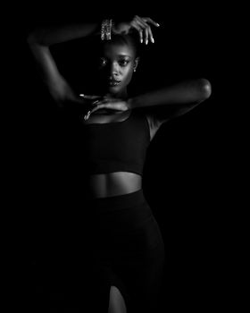 Artistic black and white portrait of a woman posing gracefully with dramatic lighting.