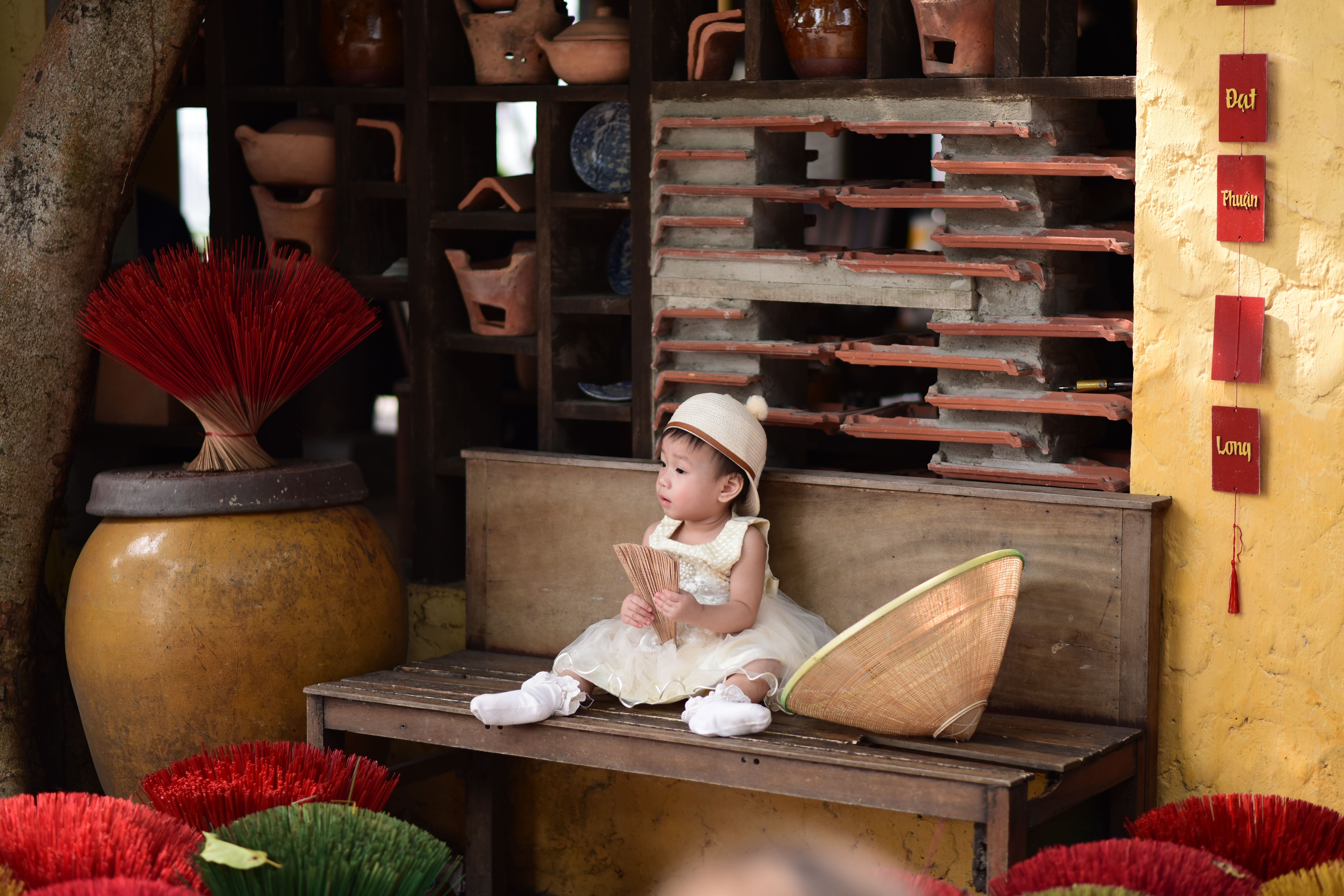 Adorable Child in Traditional Setting Holding Fan · Free Stock Photo