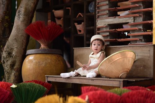 Free Cute child in a hat surrounded by colorful incense sticks and Asian decor elements. Stock Photo
