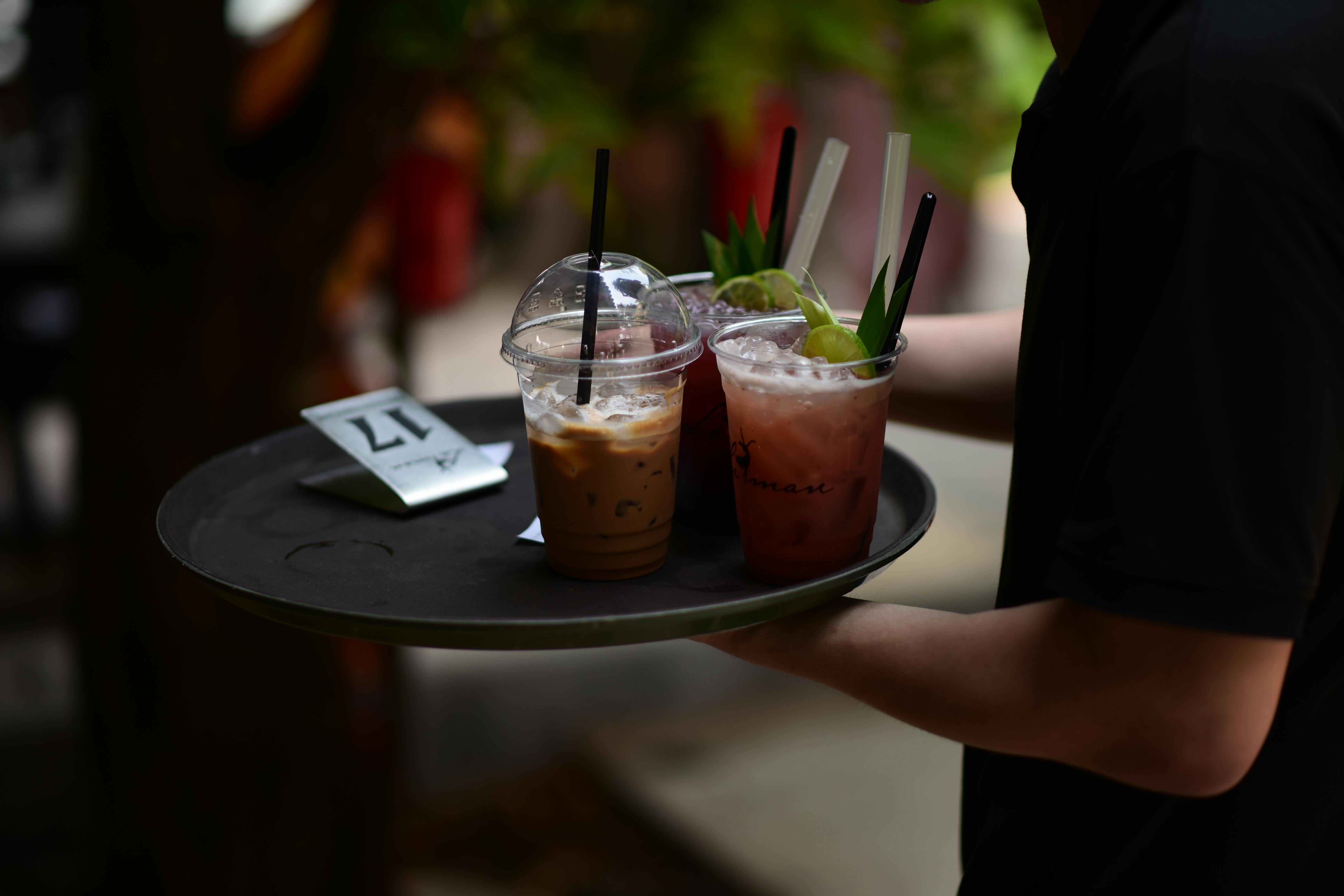 Miễn phí Một người phục vụ mang khay đồ uống lạnh ra trên sân hiên ngoài trời đầy nắng. Ảnh lưu trữ