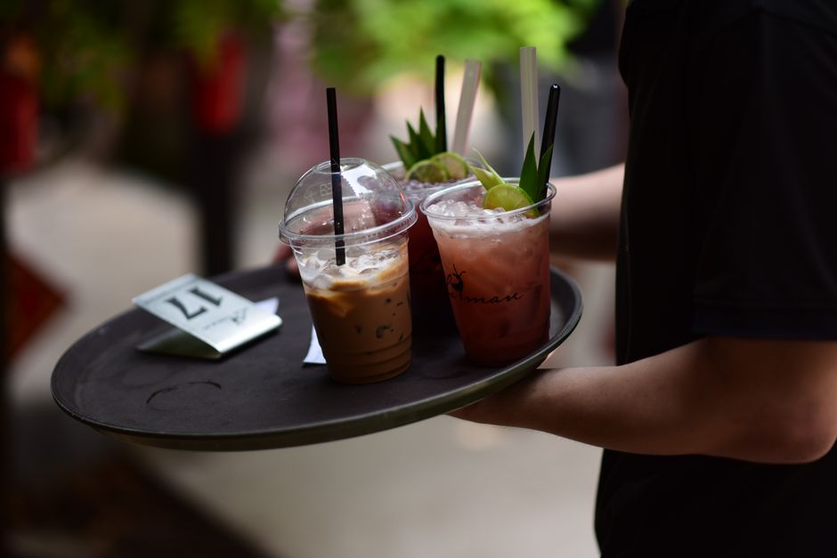 A selection of iced beverages on a tray outdoors, perfect for a refreshing break.