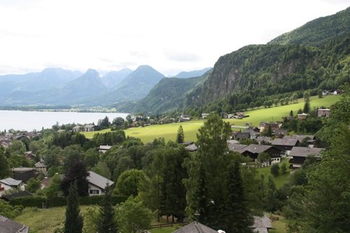 Free A serene view of a village in the Austrian Alps with lush greenery and mountains. Stock Photo