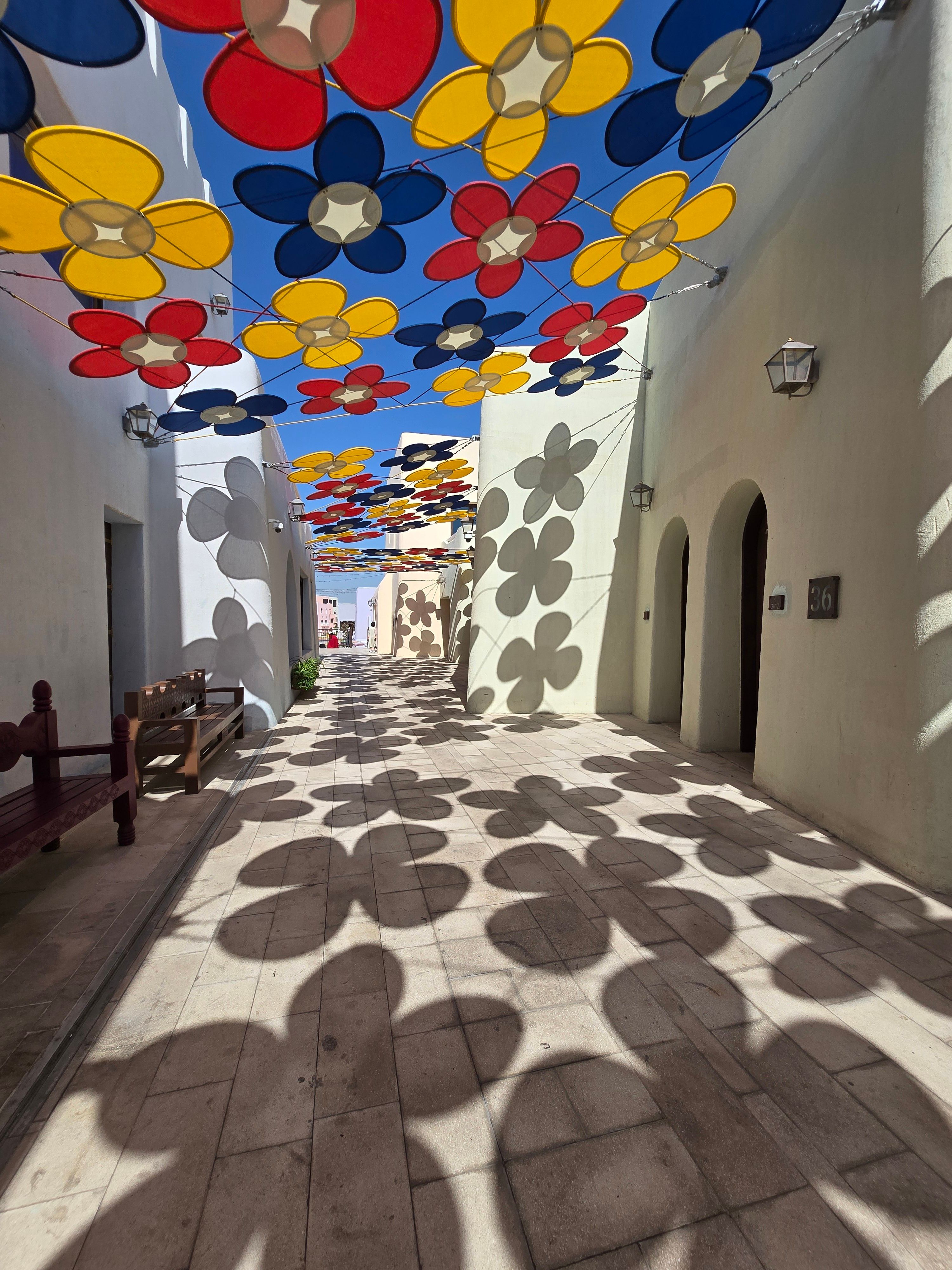 Colorful flower patterns create stunning shadows in a sunny alley in Doha, Qatar.