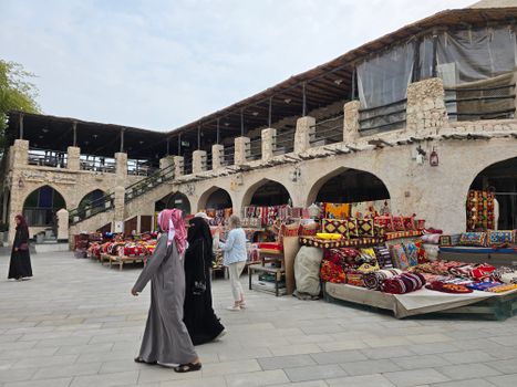 Bustling outdoor souk in the UAE showcasing vibrant textiles and traditional architecture.