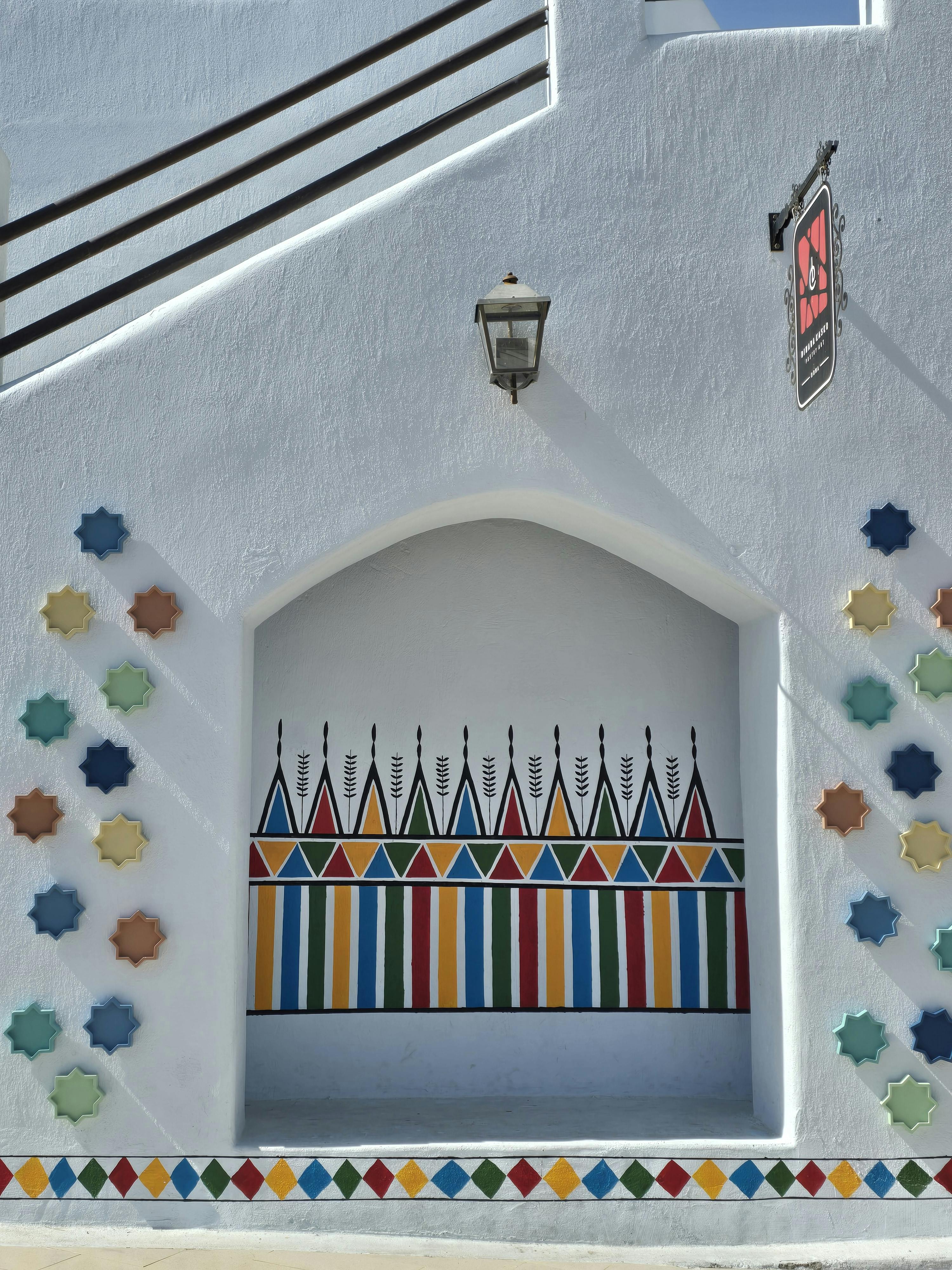 bezplatná Zářivé geometrické nástěnné umění zdobí sluncem zalitou fasádu budovy. Základová fotografie