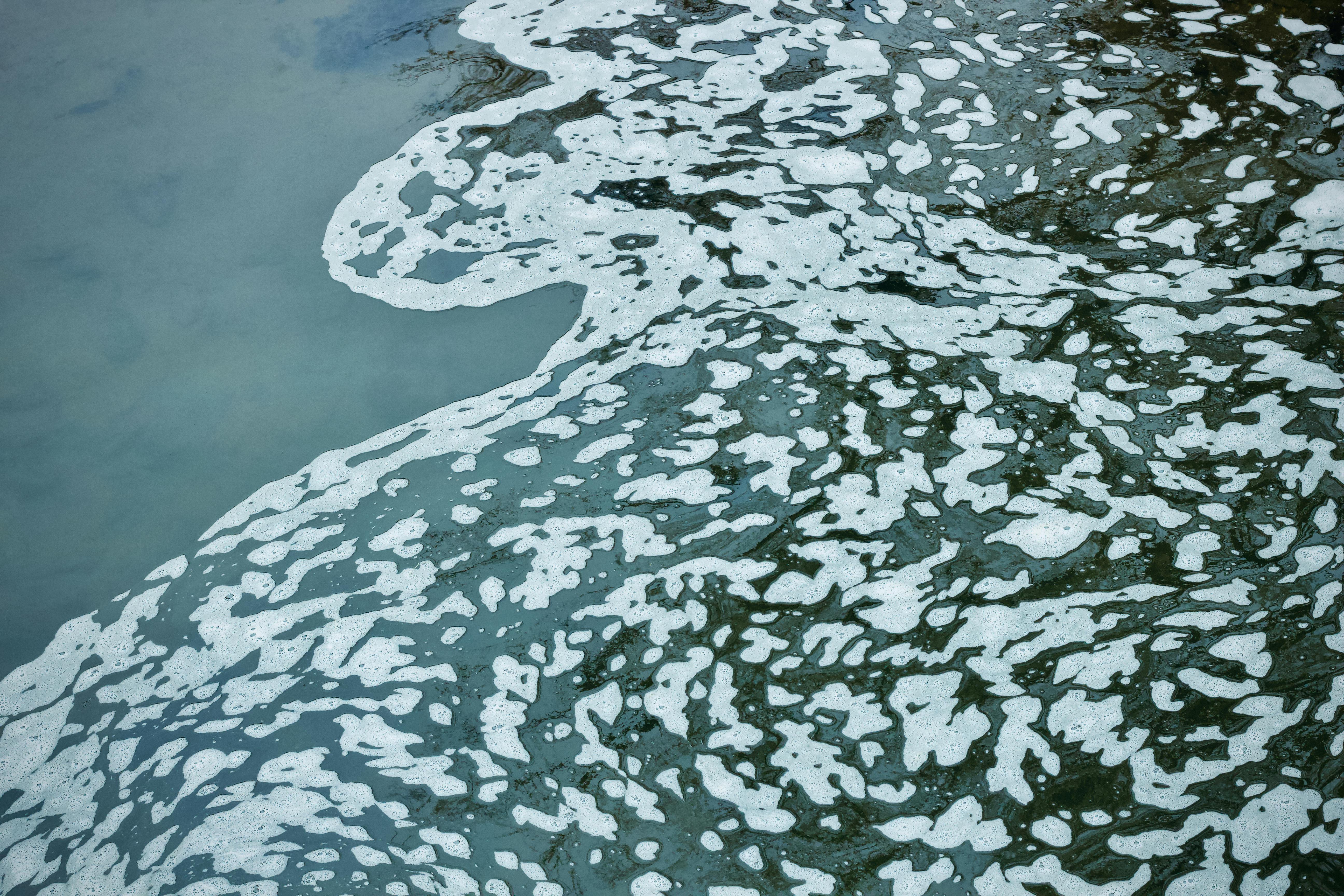 Kostenlos Abstrakte Darstellung von Wasser mit schaumigen Mustern, die eine künstlerische Textur erzeugen. Stock-Foto
