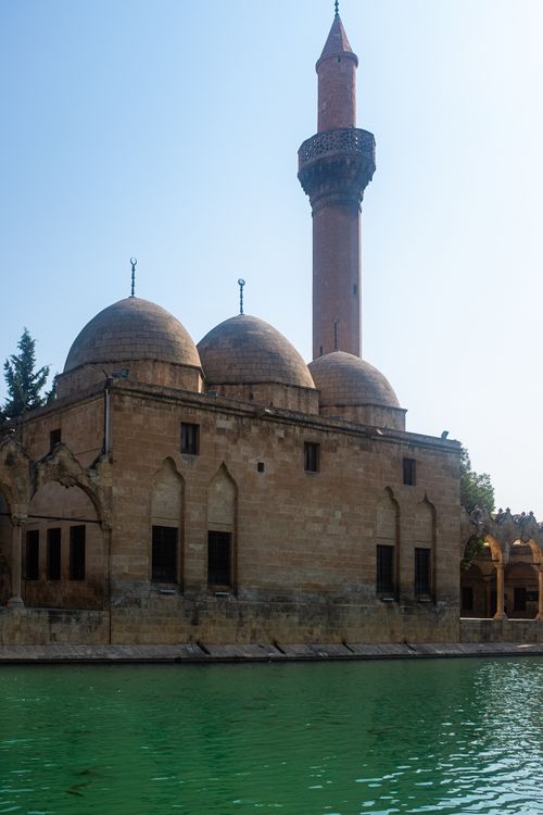 Free Tranquil scene of a historic mosque with a minaret near a reflective pool under clear skies. Stock Photo