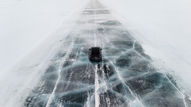 Car driving on a frozen icy road in Canada. Captured from above, showcasing winter's beauty.
