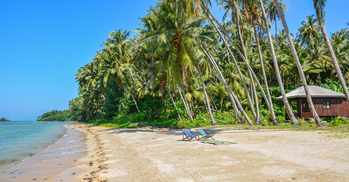 Stunning tropical beach on Ko Mak island, Thailand, with palm trees and clear blue skies.