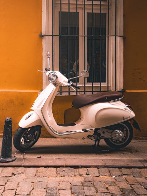 Free Elegant white Vespa parked against a vibrant yellow wall in Istanbul, perfect for urban exploration imagery. Stock Photo