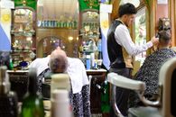 A classic barbershop in Buenos Aires with a barber styling a client's hair, surrounded by vintage decor.