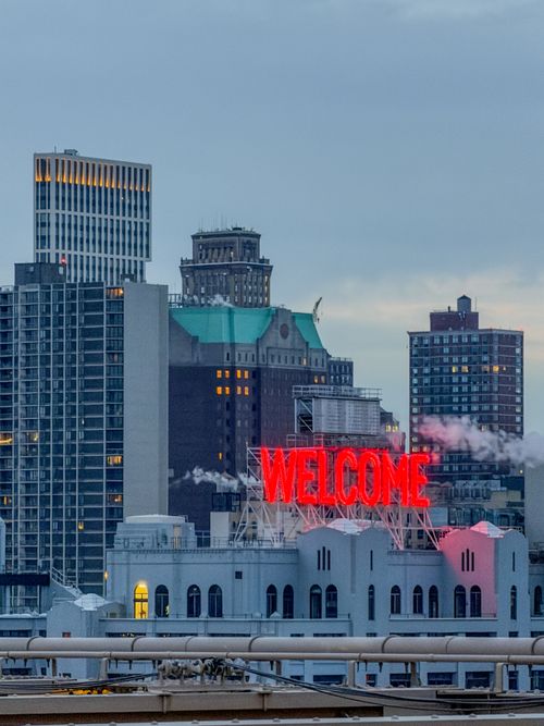 Free Skyline view featuring 'Welcome' sign in New York City at twilight. Stock Photo