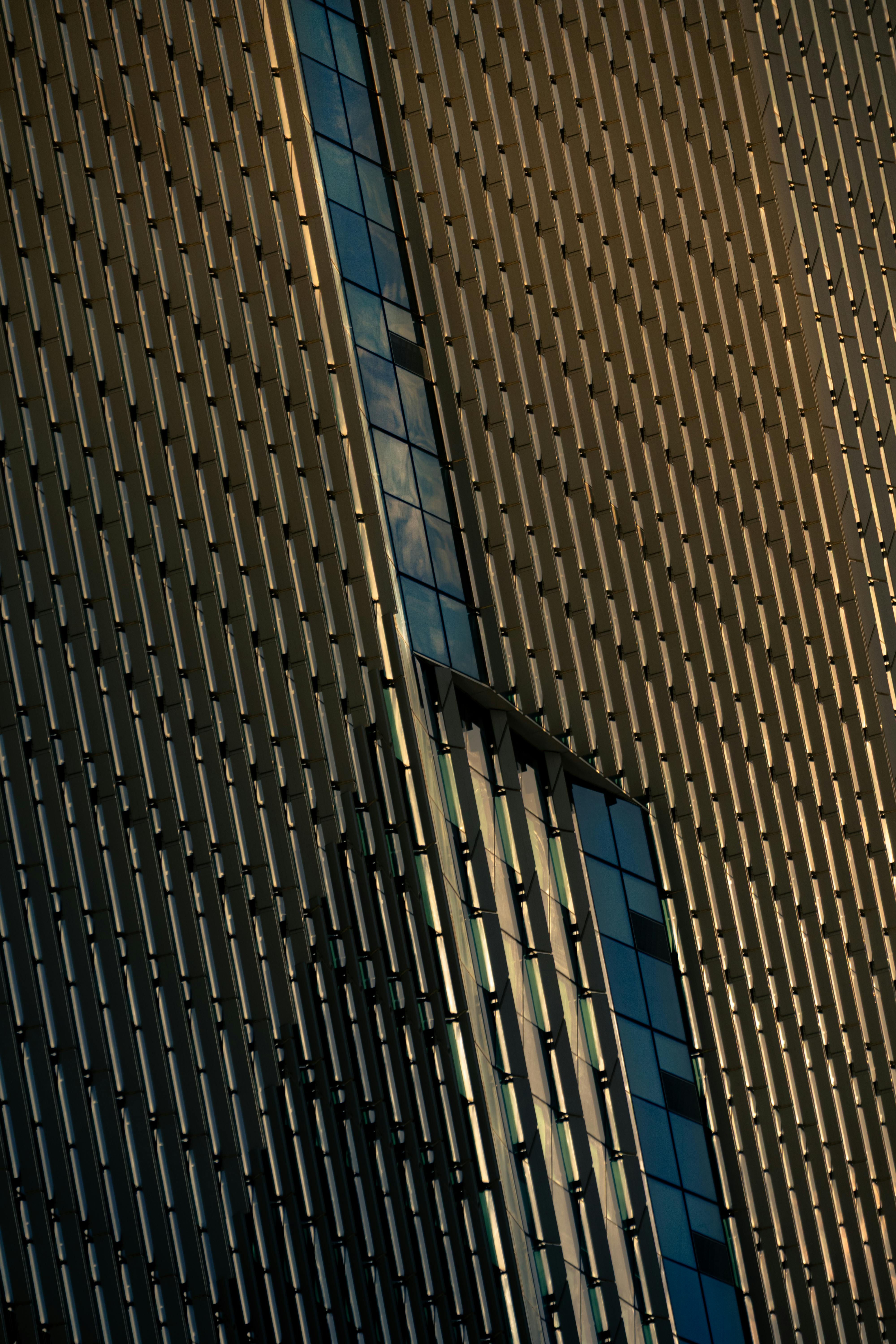 gratis Detailopname van een moderne gebouwgevel met verticaal paneelontwerp en reflecties. Stockfoto