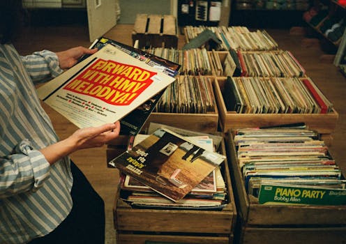 Explore vintage vinyl records in a cozy record store setting in the UK.