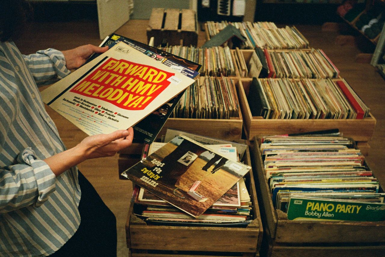 Explore vintage vinyl records in a cozy record store setting in the UK.