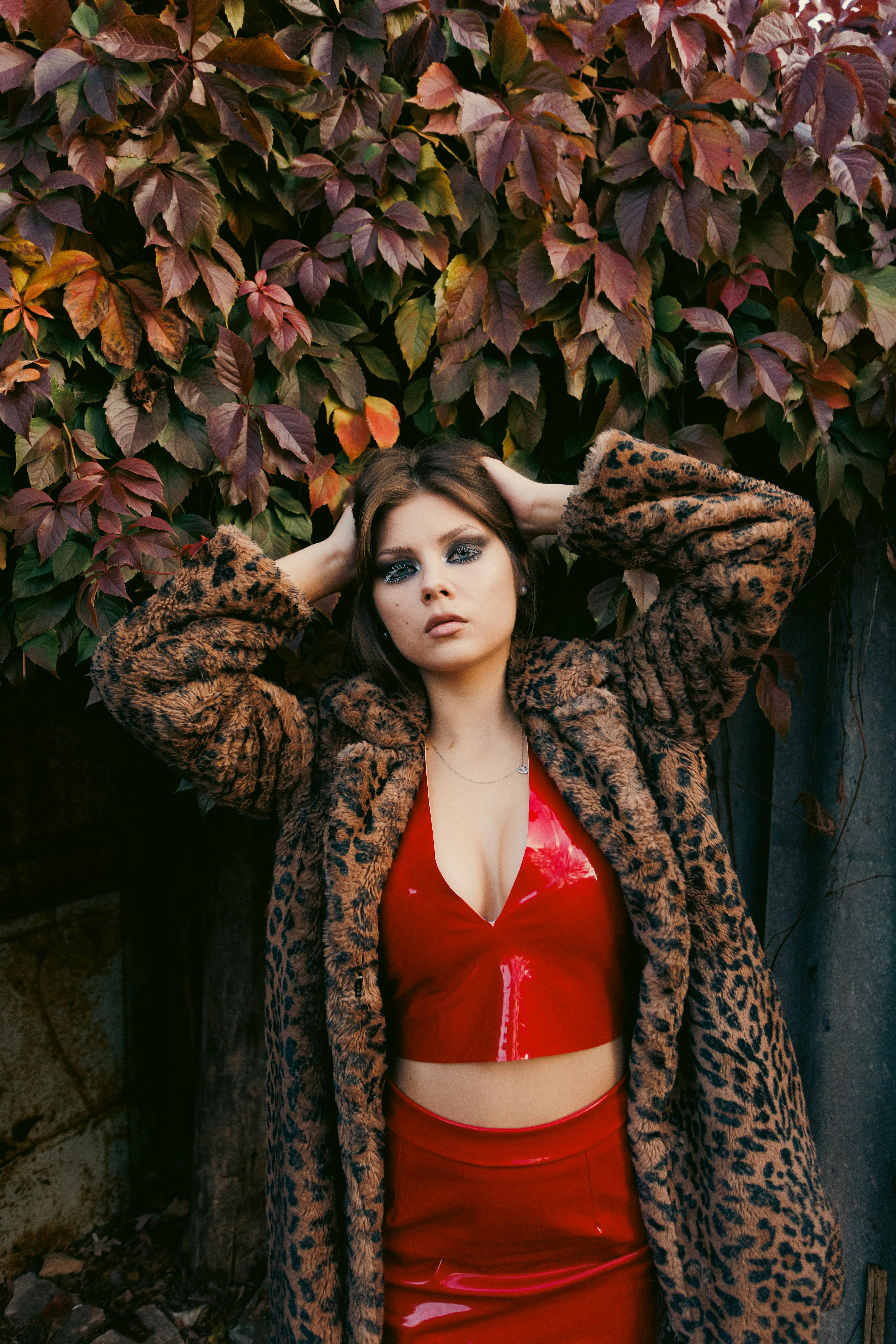 ฟรี หญิงสาวสวยในชุดสีแดงโพสท่าท่ามกลางใบไม้ร่วงสีสันสดใส คลังภาพถ่าย