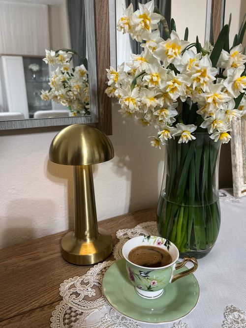 Free A cozy indoor setup featuring white daffodils, a cup of coffee, and elegant decor. Stock Photo