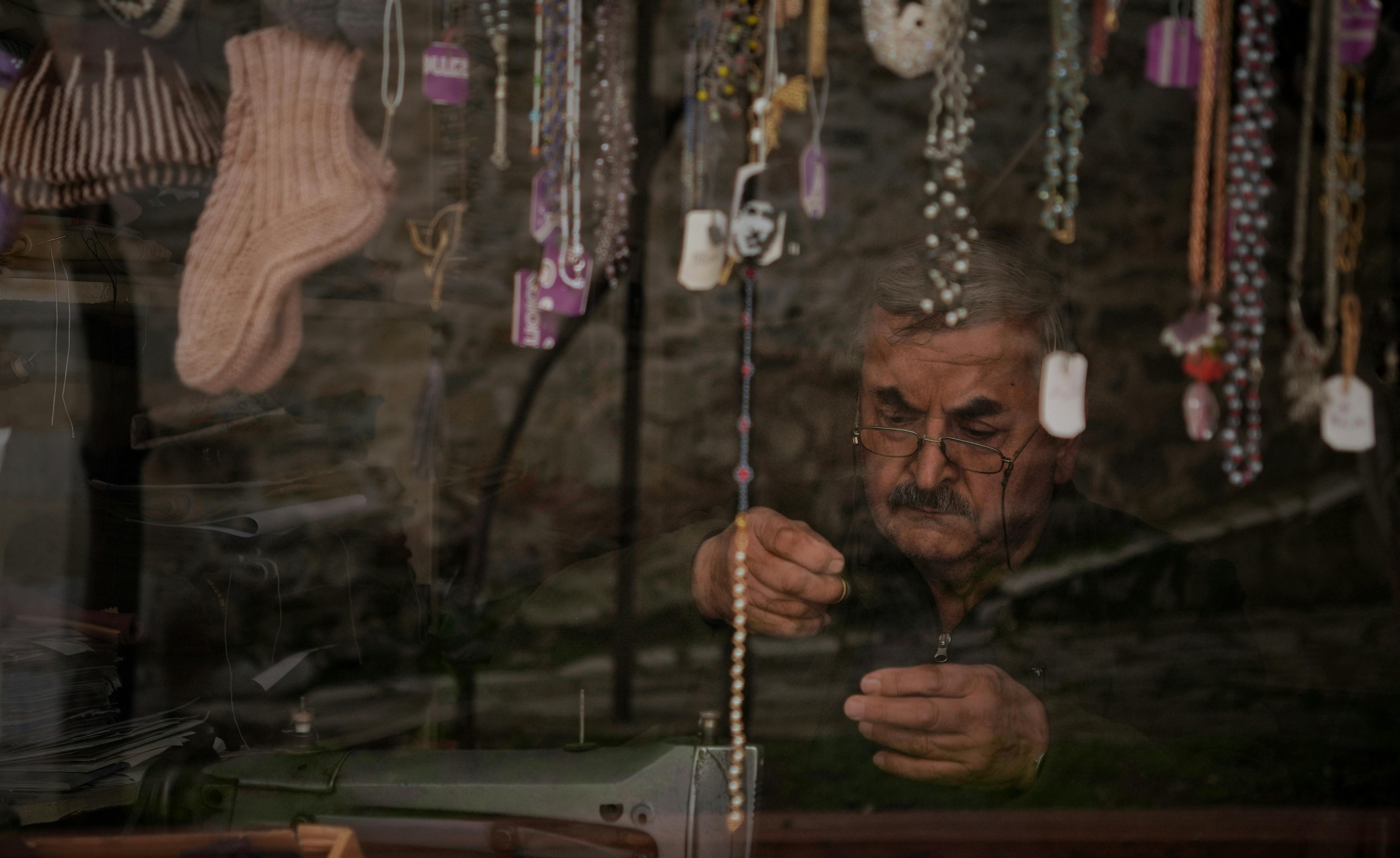 ฟรี ช่างฝีมือผู้ชำนาญกำลังประดิษฐ์เครื่องประดับอยู่ภายในโรงงานในเมืองซาฟรานโบลู ประเทศตุรกี ภาพสะท้อนบนหน้าต่างที่มีของตกแต่ง คลังภาพถ่าย